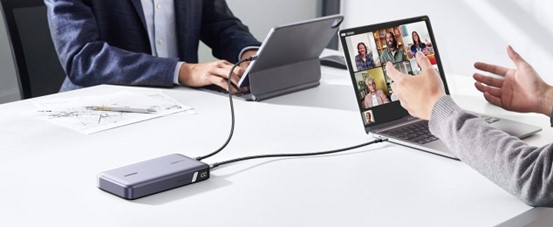 UGREEN powerbank charging laptops during a meeting.